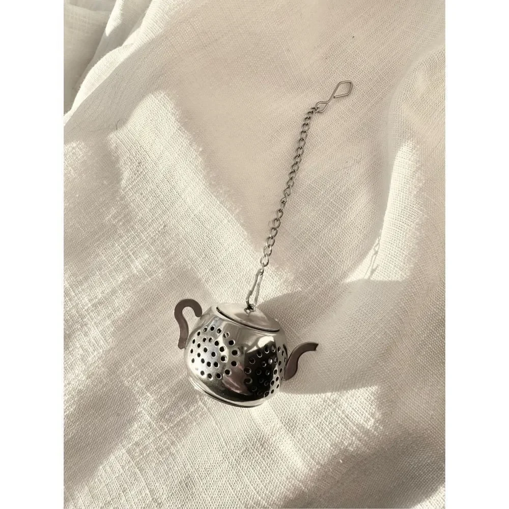 Silver colored teapot, tea diffuser